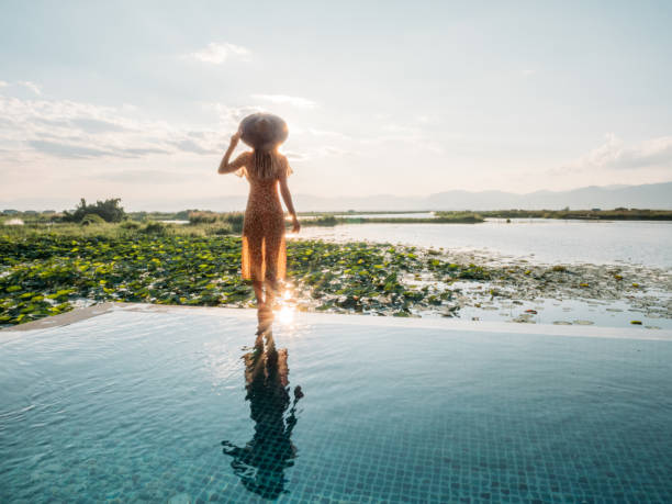kobieta idąca na skraju basenu bez krawędzi ciesząc się luksusowymi wakacjami - romance tropical climate ideas travel destinations zdjęcia i obrazy z banku zdjęć
