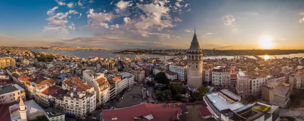 Aerial panorama of the Galata Tower in Istanbul, Turkey. Aerial view of landmark at golden hour with beautiful sunlight.