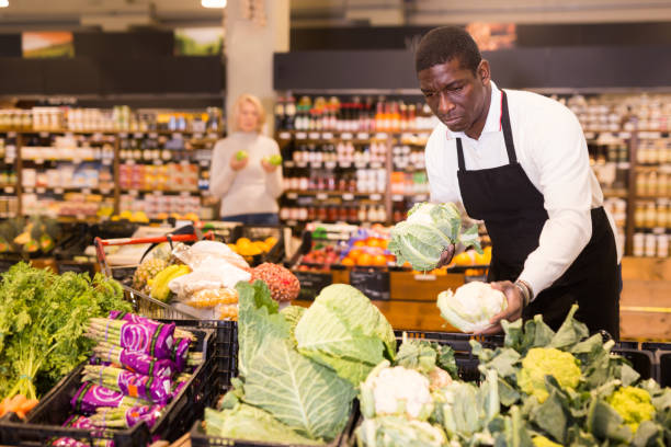 istock Adult African male worker arranging vegetables 1285335907