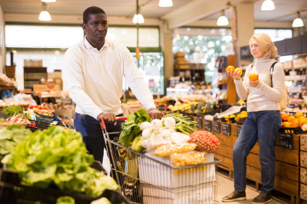 istock Man carrying purchases in trolley cart 1285335909