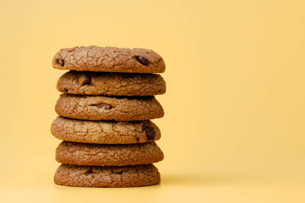 istock Pile of chocolate chip cookies on yellow backgreound 1285336010