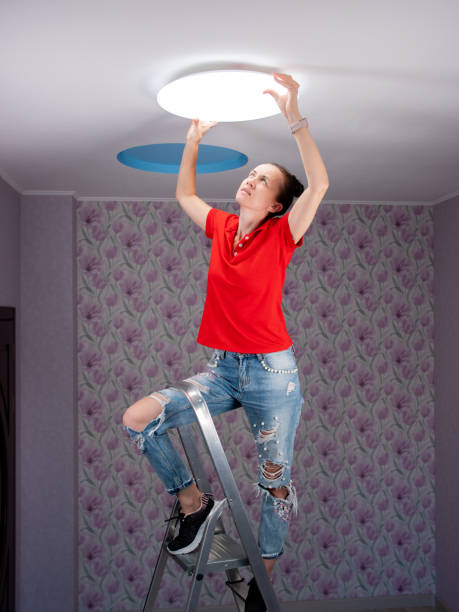 istock The woman in the room sets the led ceiling light. 1285336767