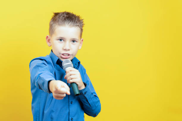 istock A boy with a microphone and an outstretched hand. You're next. Copy space 1285337092