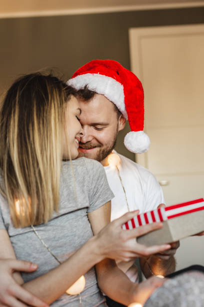 istock Young couple in bed opening Christmas presents 1285337926