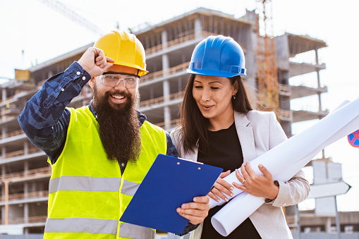 Architect and construction worker  having work meeting  at construction site. Construction business