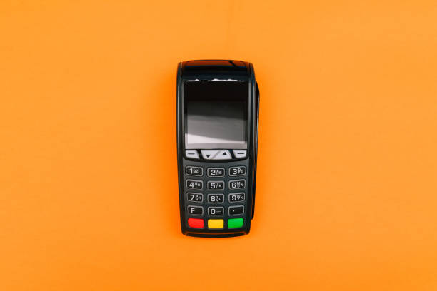 istock Payment terminal isolated on orange background. A contactless device for paying for purchases with a bank card or smartphone. E-commerce and business 1285351193