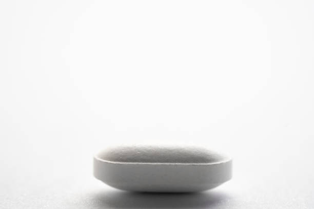 istock Little white pill bright white background medical photo 1285351625