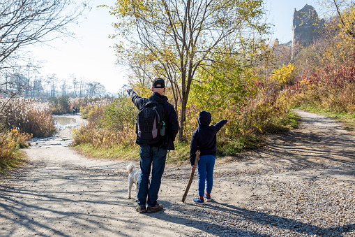Father and son exploring near an old granite quarry pond. Taken on an autumn day at Quarry Park in Minnesota, USA.