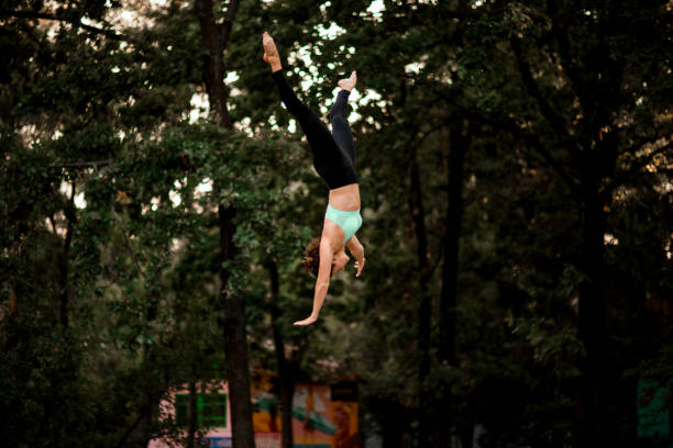 istock woman jumping masterfully and performs trick upside down in the air 1285355877