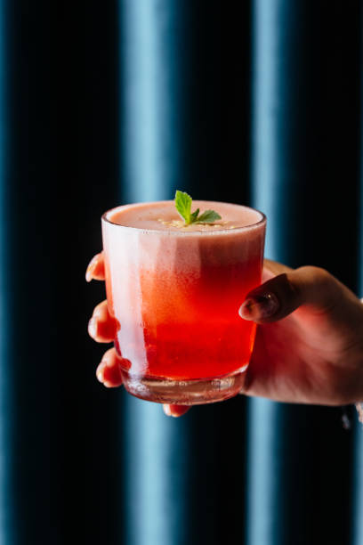 istock red strawberry alcoholic cocktail in a woman's hand 1285358171