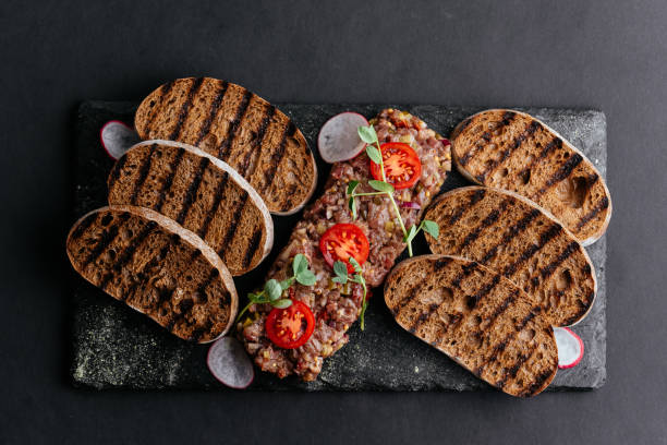 istock beef tartare with rye croutons on a black background 1285358178