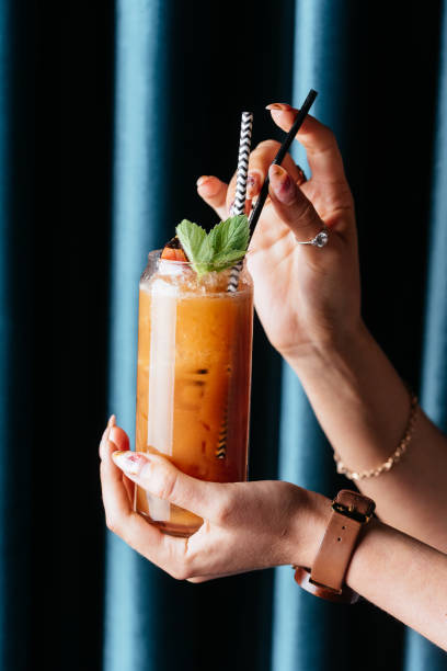 istock yellow citrus cocktail in women's hands 1285358215