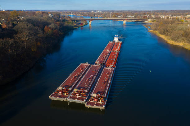 Barge on the Illinois River at Ottawa, Illinois A red barge ships cargo down the Illinois River near Ottawa, Illinois. Aerial photograph via drone. barge stock pictures, royalty-free photos & images
