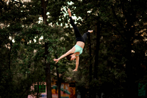 istock pretty woman jumping masterfully and performs trick upside down in the air 1285361683