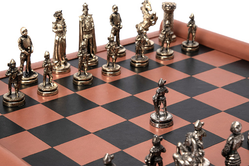 Natural amber different chess pieces figures standing on lacquer surface board on white. Close up game concept competition, Classic Tournament of confrontation.