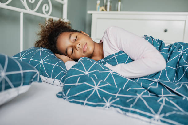 una bambina dorme a letto - dreams child sleeping little girls foto e immagini stock