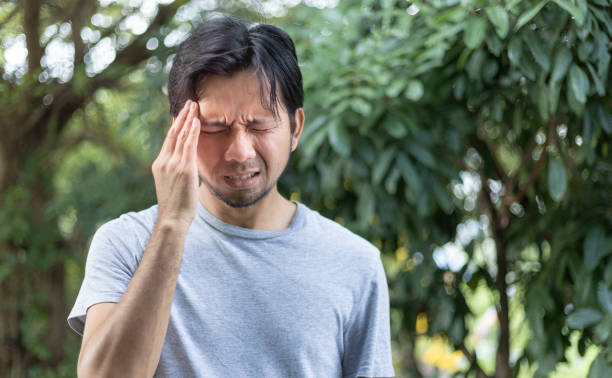 istock young asian man suffering from severe headache outdoor 1285364863