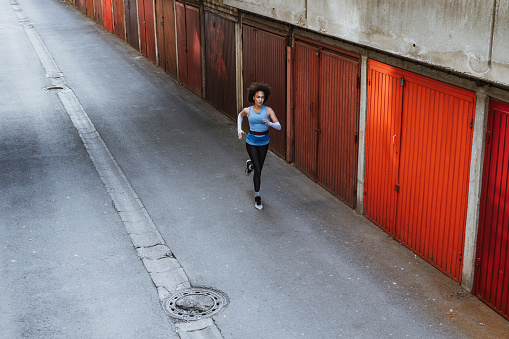 Fit health conscious woman with an Afro haircut doing morning exercises in the city