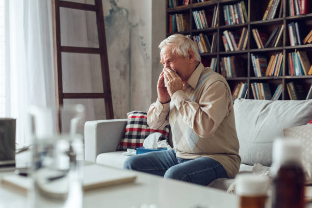 istock Senior man alone sitting at library feeling sneezing sick 1285369475