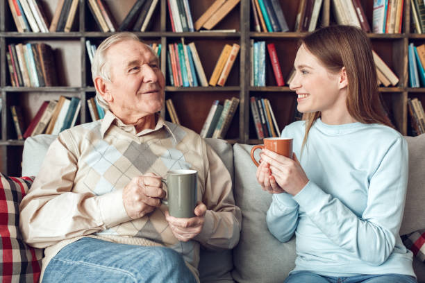 istock Father and daughter at home library sitting drinking tea talking joyful 1285369482