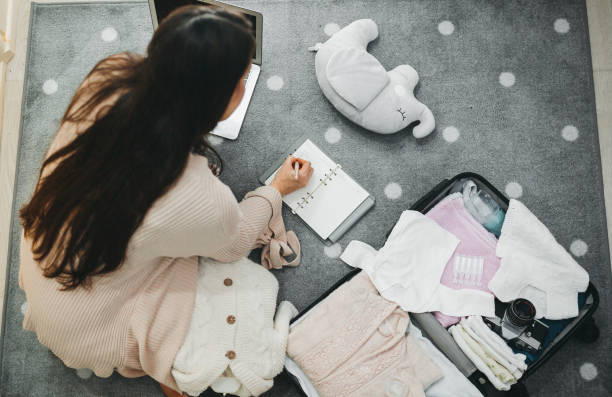 A pregnant woman prepares a bag for the hospital A pregnant woman prepares a bag for the hospital pregnancy and childbirth stock pictures, royalty-free photos & images