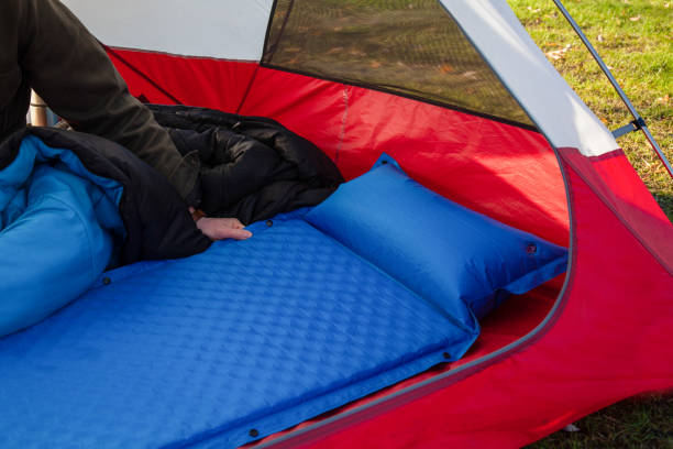 A close up of a blue camping inflating mattress pad A man gets his tent and sleeping bag ready at a campground by inflating and setting up his blue blow-up mattress pad to put for under his sleeping bag swimming float stock pictures, royalty-free photos & images