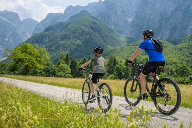 istock Father and son riding bicycles on country road 1285372578