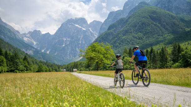 istock Father and son riding bicycles on country road 1285372731