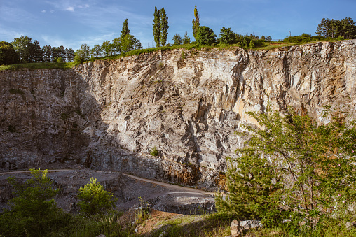 view of mining plant with quarry, surrounded by forest and green fields. Industrial stone mining