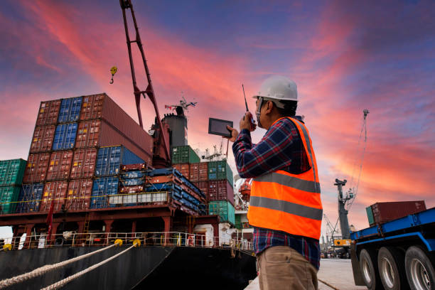 istock Engineers and crane.smiling dock worker holding radio and ship background 1285373775