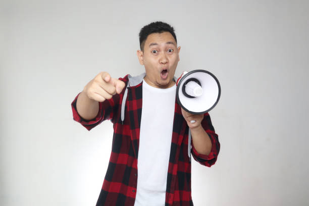 istock Young Asian man making announcement, marketing advertisement concept, Smiling expression using megaphone 1285379165