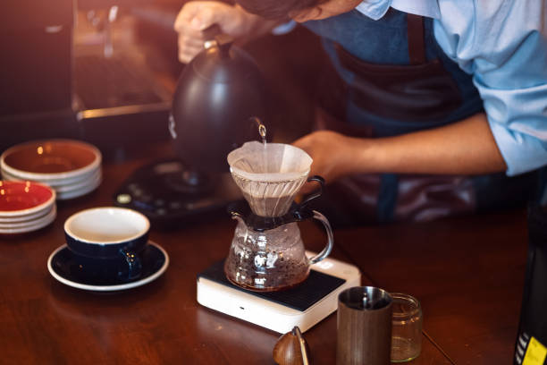 istock barista pouring boiling water from kettle to drip coffee maker. 1285379452