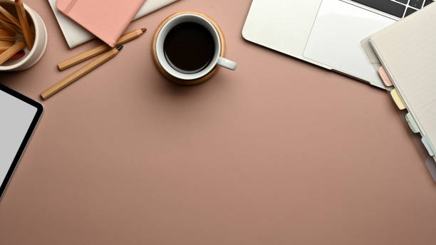 istock Workspace with digital devices, stationery, coffee cup and copy space on pink table 1285387658