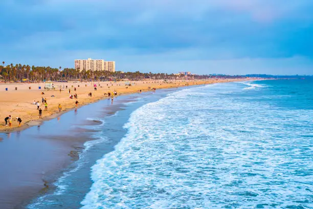 Crowded beach day on California coast in America. People/ locals/ tourists enjoy sunny summer day on scenic coastal landscape and ocean. Freedom of being outdoors, relaxing weekend setting.