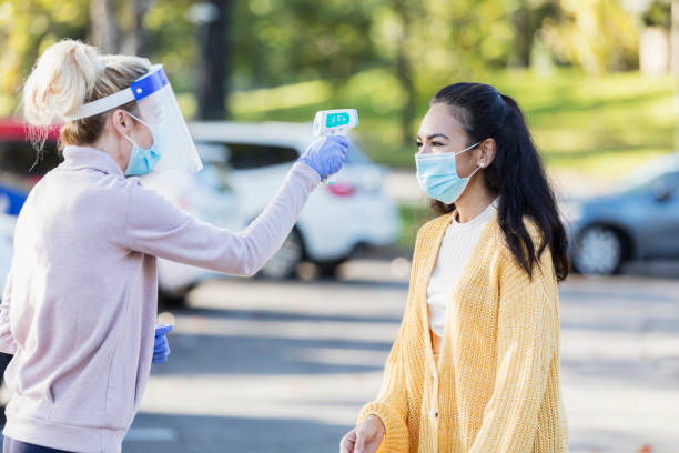 istock Woman having temperature taken during covid-19 1285390992
