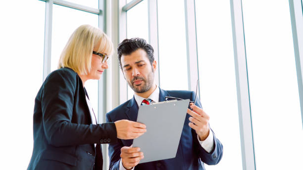 istock Two business people talk project strategy at office 1285392878