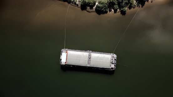 aerial view of unserviceable barge boat anchored in harbor waiting maintenance.