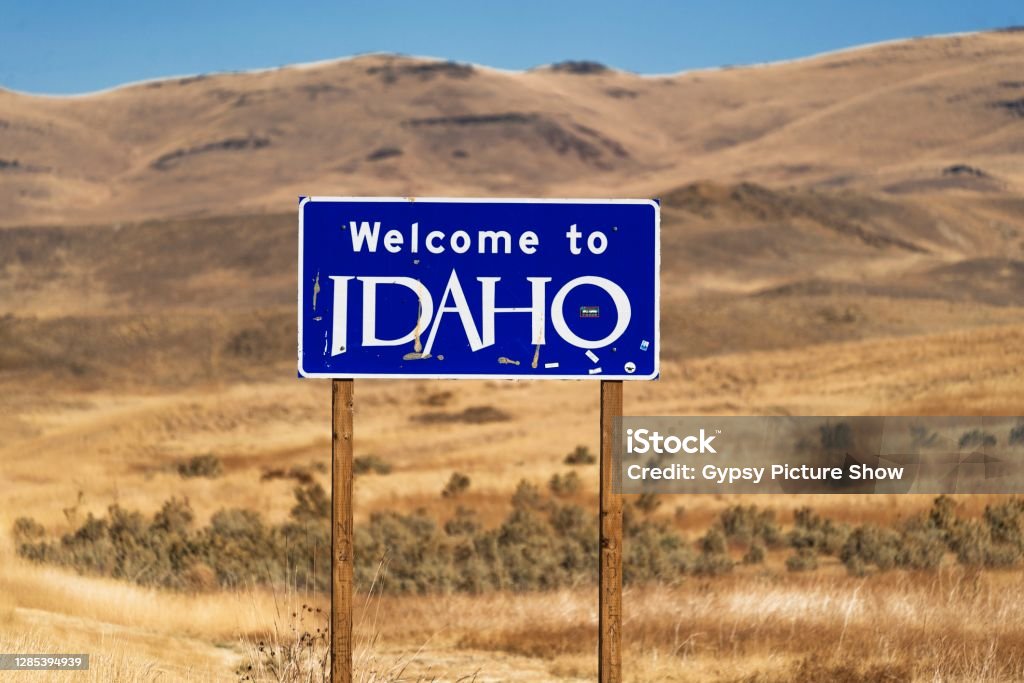 "Welcome To Idaho" state road side sign This image shows an official "Welcome To Idaho" state road side sign with a beautiful landscape behind. Idaho Stock Photo