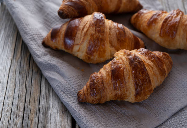 istock Croissant on a cloth placed on an old wooden background 1285397495
