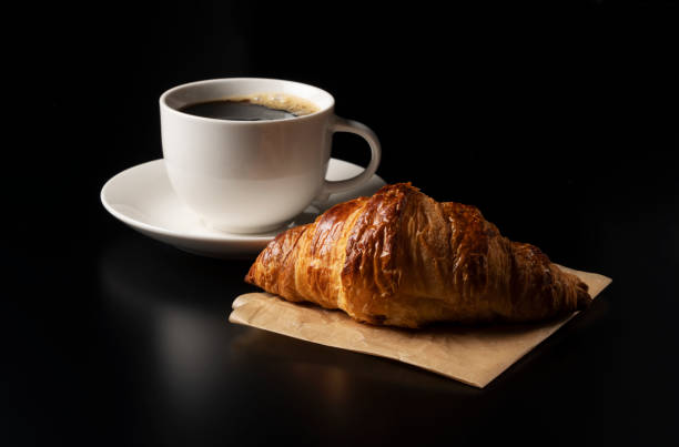 istock One croissant and hot coffee placed on a black background 1285397543