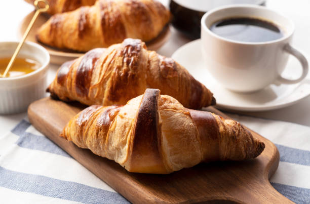 istock A croissant with coffee and honey behind it. Breakfast images 1285397708