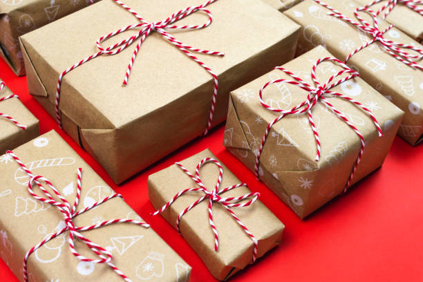 istock Many handcraft gift boxes on red background. Christmas packaging wrapped striped rope and vintage paper 1285397725
