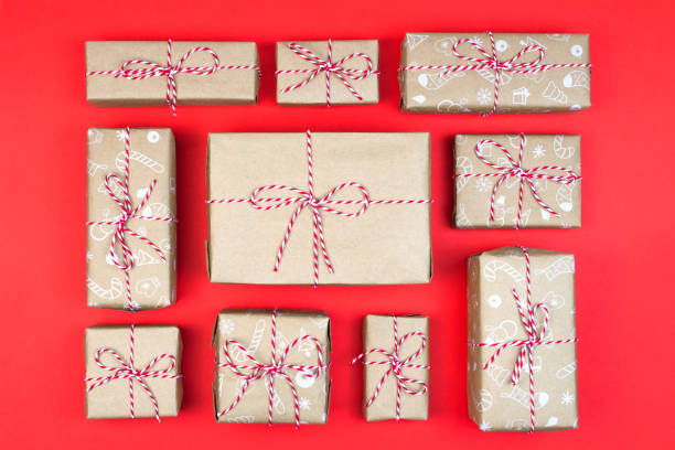 istock Many craft gift boxes on red background. Christmas packaging wrapped vintage paper knolling presents 1285397727