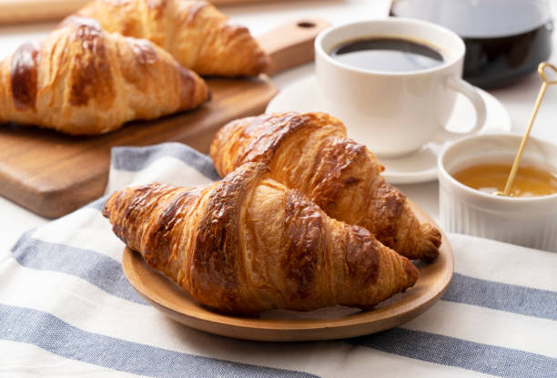 istock A croissant with coffee and honey behind it. Breakfast images 1285397795