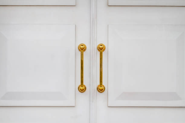 White church doors with golden handles. Closeup