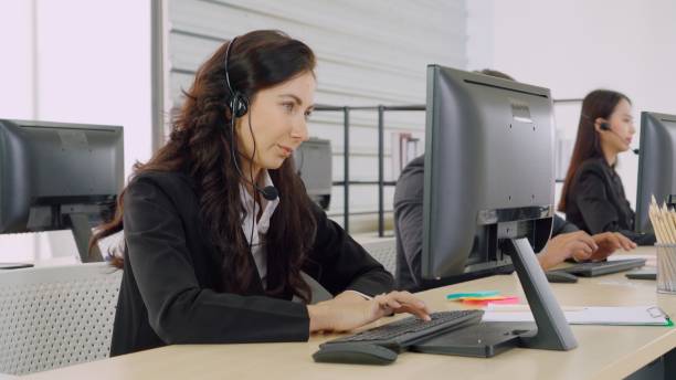 istock Business people wearing headset working in office 1285402954
