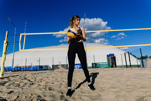 A female beach volleyball athlete on the volleyball court