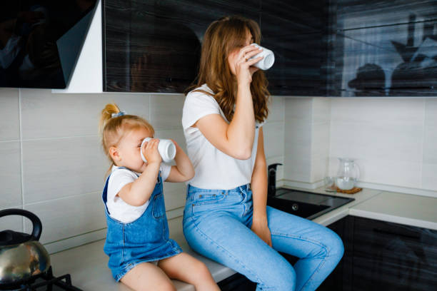 istock Mother is drinking tea in the kitchen with her little daughter. 1285409858