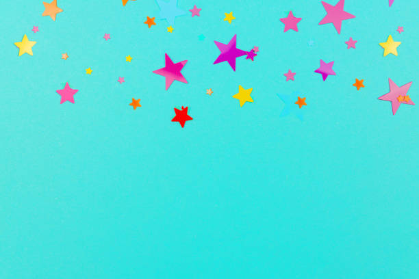 istock multicolored backdrop of colored stars confetti on a blue background. 1285411939