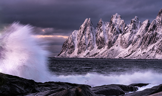 Devil's teeth rock formation on the coastline of the sea during winter blue hour in Senja, Norway.